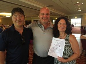 Vince Holmes (middle) of U-Freight, winner of Qatar Airways tickets presented by Kenny Oda and Margherita Caruso.